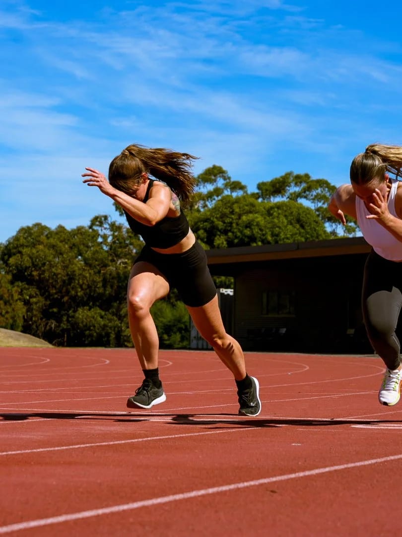 Two athletes driving out of the blocks on the track